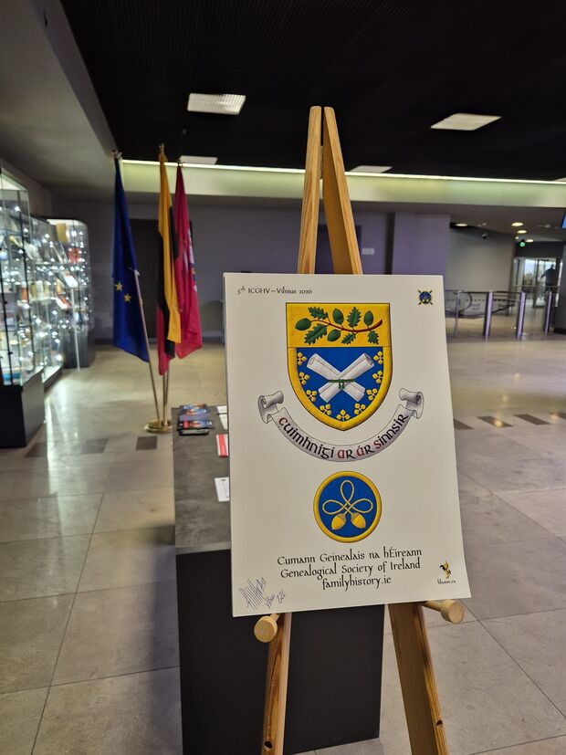 Escudo de azur, dos pergaminos enrollados en sotuer de plata, ligados con una cinta puesta en faja de sinople, una bordura trebolada de oro; brochante sobre el todo un jefe de oro cargado de una rama de roble hojada y frutada al natural. Insignia de azur, un nudo celta trebolado con dos bellotas pendientes de cada extremo; una bordura todo de oro.