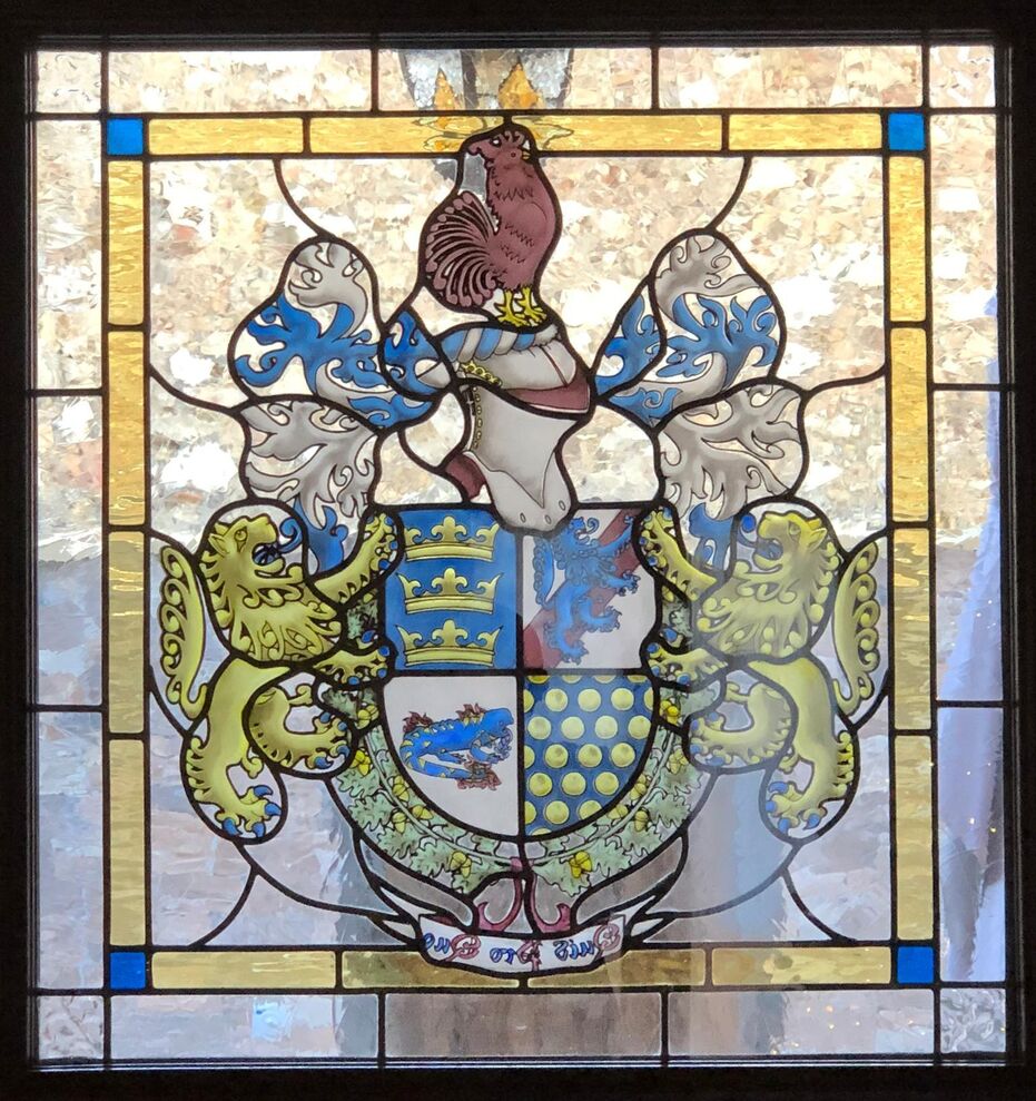 Quarterly: 1 Argent, a bend Gules, overall a lion rampant Azure; 2 Azure, three crowns in pale Or; 3 Azure sem� of bezants; 4 Argent, a salamander fesswise Azure, spotted Or, enflamed Or and Gules. Crest: Upon a helm with a wreath Argent and Azure, a rooster Gules, beaked and membered Or. Mantling: Azure doubled Argent. Supporters: Two lions rampant Or, armed and langued Azure. The shield is surrounded by two oak branches Vert, fructed Or, tied with a ribbon Gules. Motto: �Quid Pro Quo�.