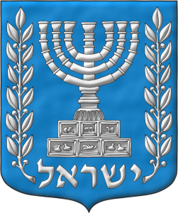 Escudo de Azur, una Menorá de plata acostada de dos ramas de olivo de lo mismo; en la punta la divisa <br /> «ישראל» de plata.